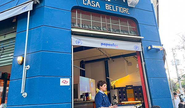 Foto da fachada do Papoulas Bar, localizado na Barra Funda em uma construção antiga, pintada de azul onde se observa o nome do antigo estabelecimento Casa Belfiore.