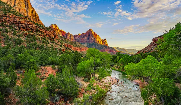 Foto do Zion National Park com montanhas de pedra, rio e vegetação.