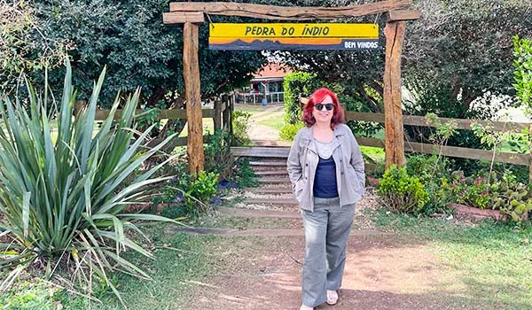Foto de Deusa Rodrigues na frente da entrada do Ecoparque Pedra do Indio.