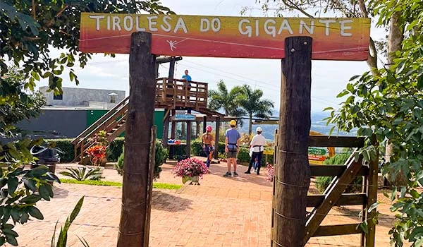 Foto da entrada com placa em dois troncos de madeira da Tirolesa do Gigante na Cuesta Paulista.