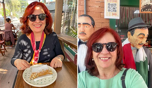 Deusa Rodrigues, de cabelos ruivos e óculos escuros, sentada à mesa de um restaurante enquanto come uma sobremesa. Ao lado, outra foto mostra a mesma mulher sorrindo para a câmera, em frente a bonecos decorativos vestidos com roupas tradicionais. O que fazer no Bixiga.