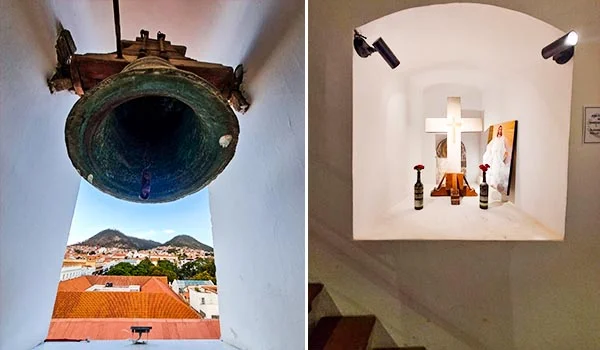 Fotografia dividida em duas partes: à esquerda, um sino antigo de bronze suspenso em uma abertura, com vista para os telhados e as montanhas da cidade de Sucre, na Bolívia; à direita, um pequeno nicho branco com uma cruz, imagens religiosas e velas, representando a tradição histórica e cultural da cidade.